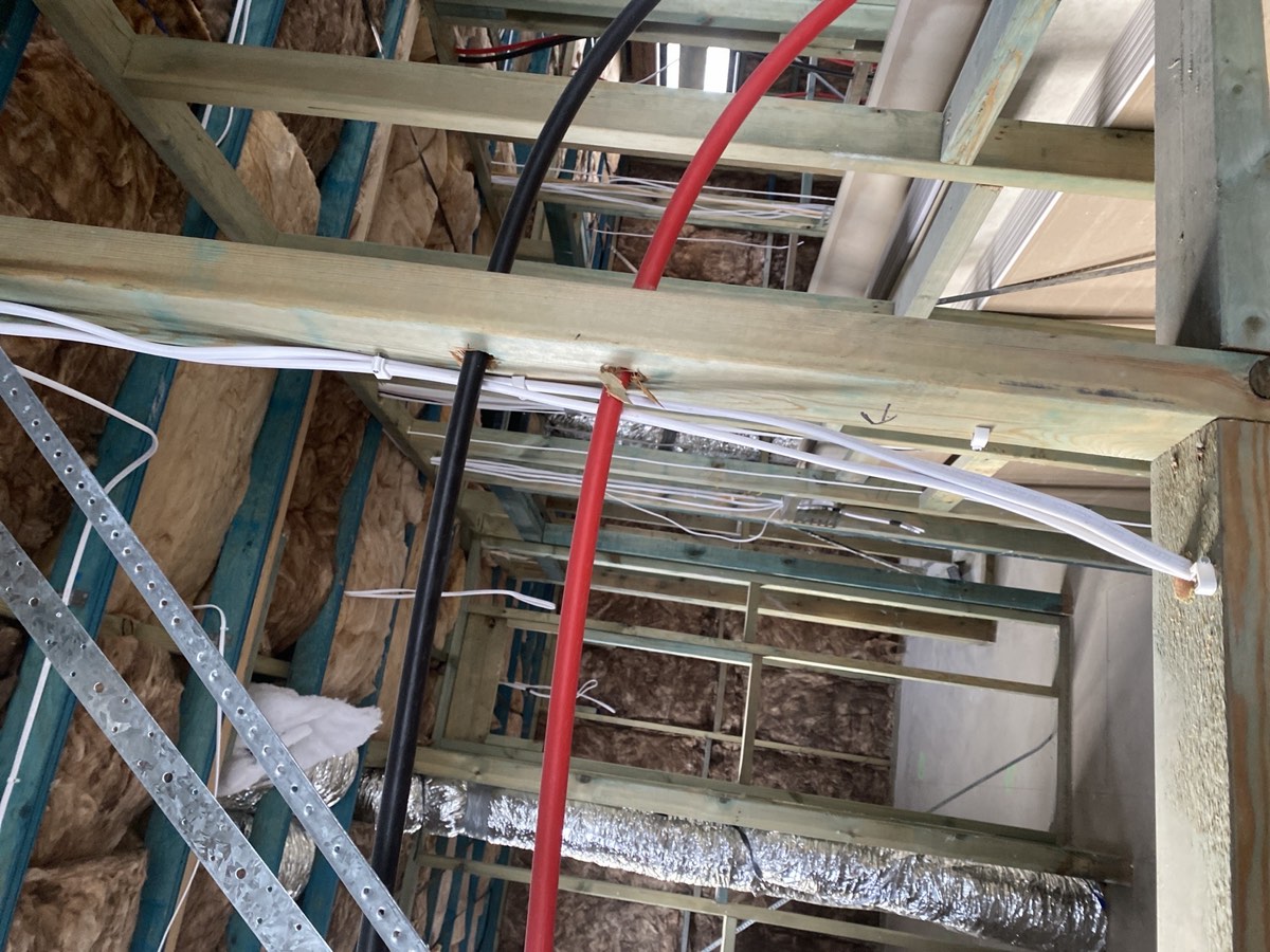 Cables in contact with hot water pipes, recorded during a lock-up inspection in Box Hill